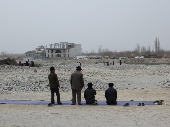 Men praying along the river banks - in the middle of jade-collecting, Hotan